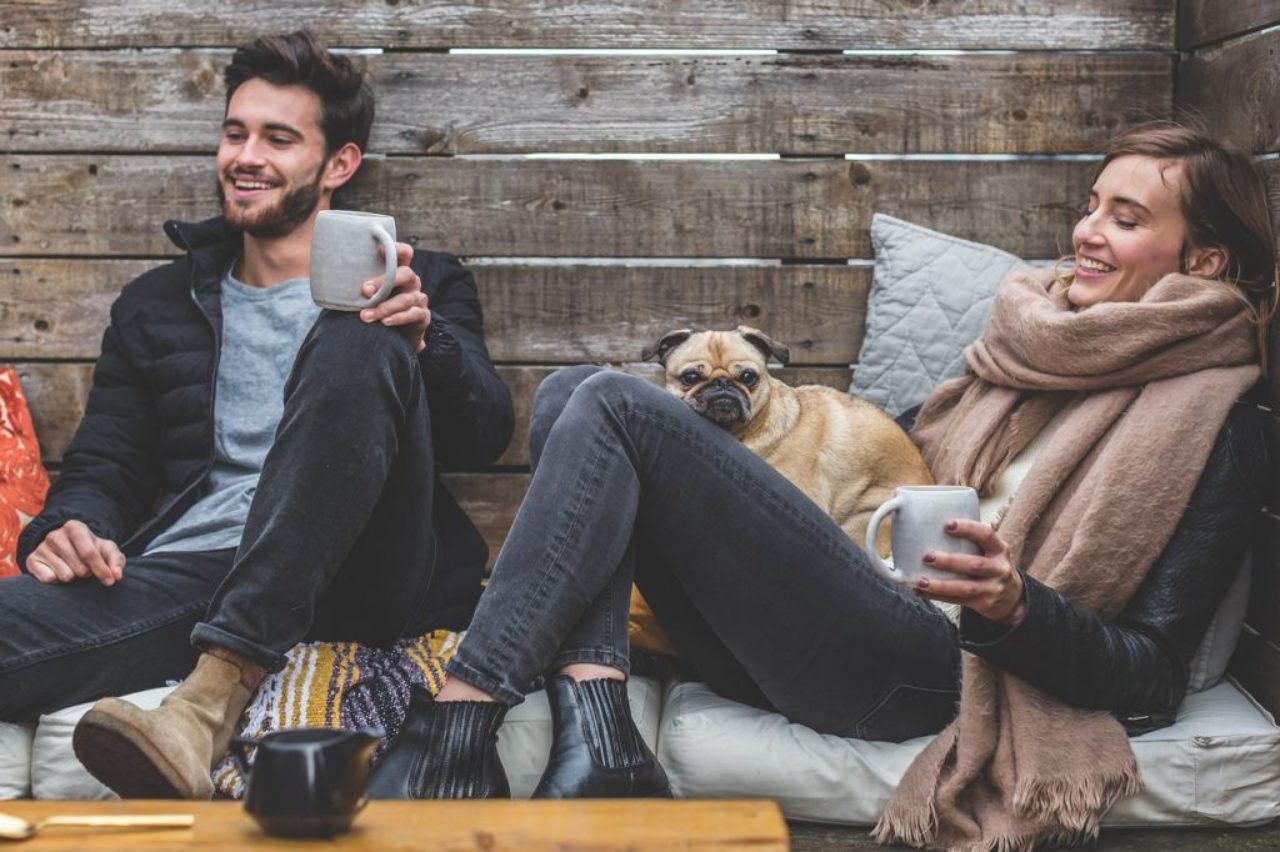 man-women-dog-sitting-enjoying-coffee