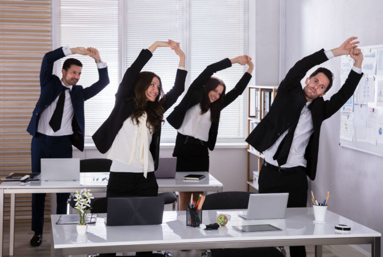 office-staff-exercising-at-their-desks-adobeStock_207357302