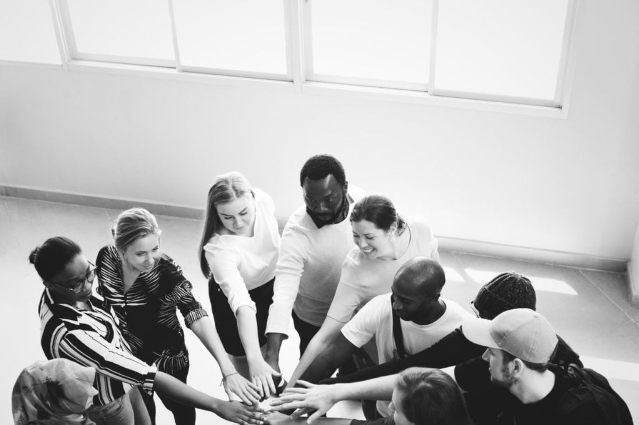 grayscale-photography-of-people-doing-team-hand-cheers