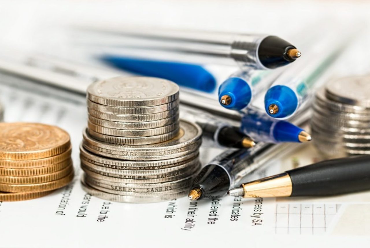 coins-pens-on-paper-with-text