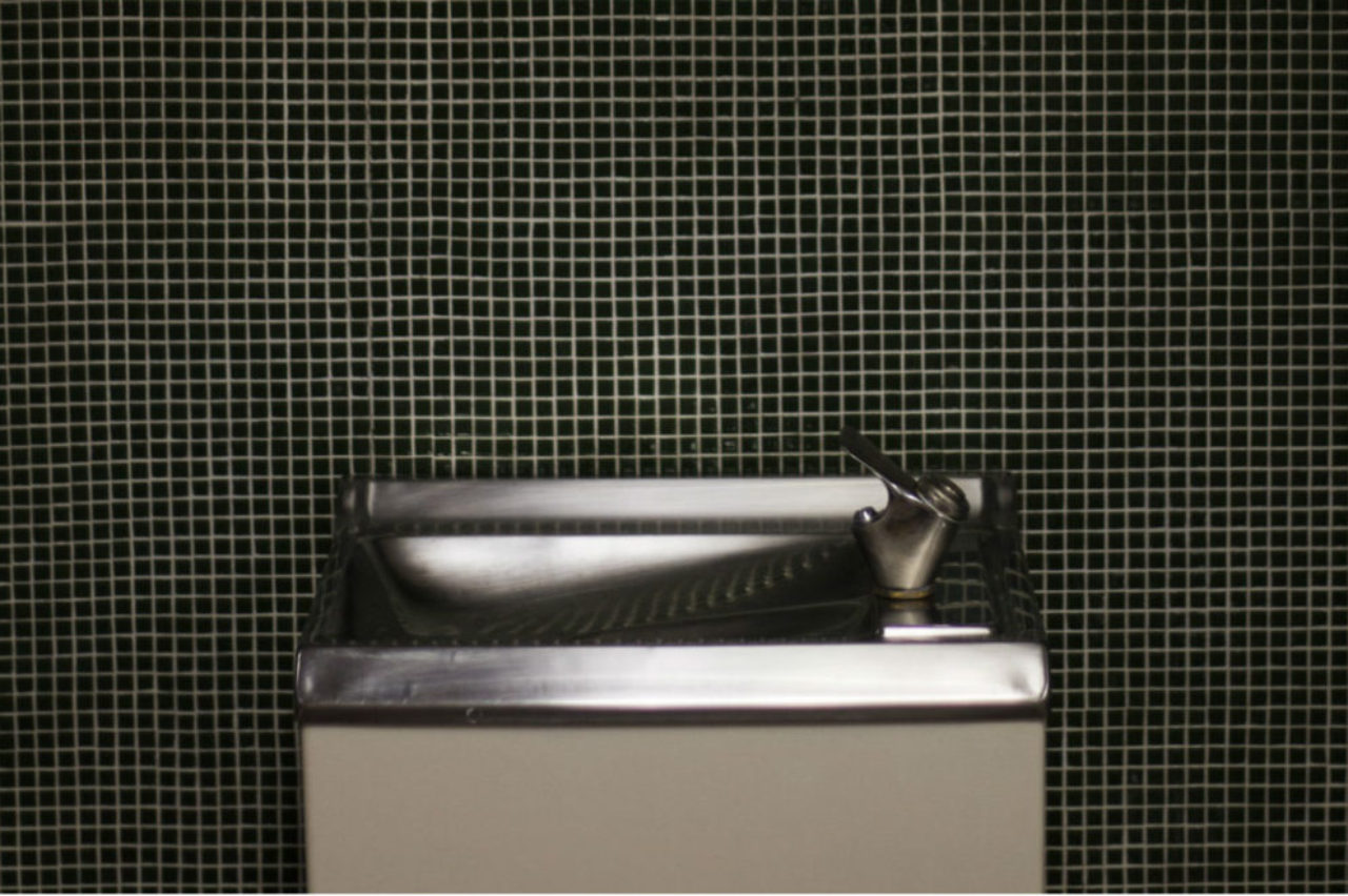 chrome-stainless-steel-water-fountain-on-black-mosiac-tile-wall