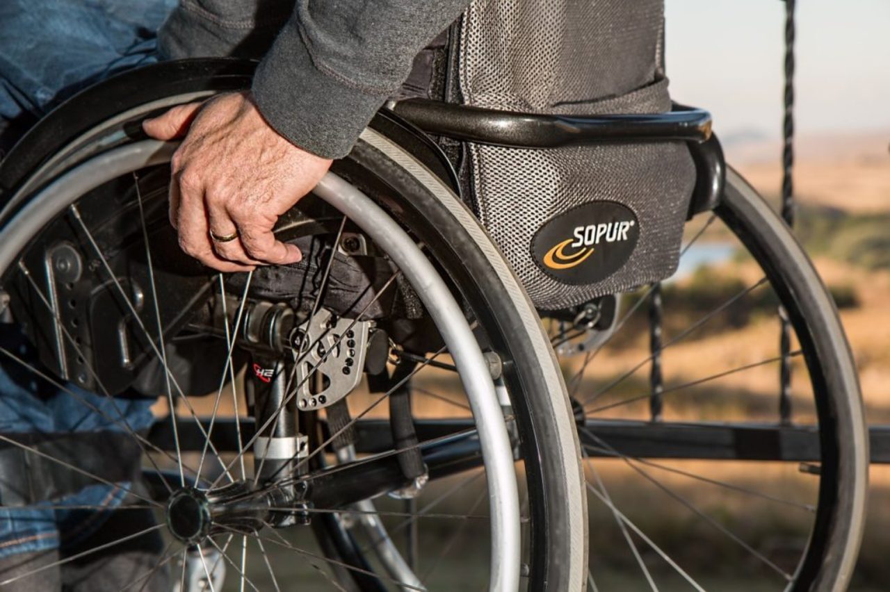 man-holding-wheelchair-wheel