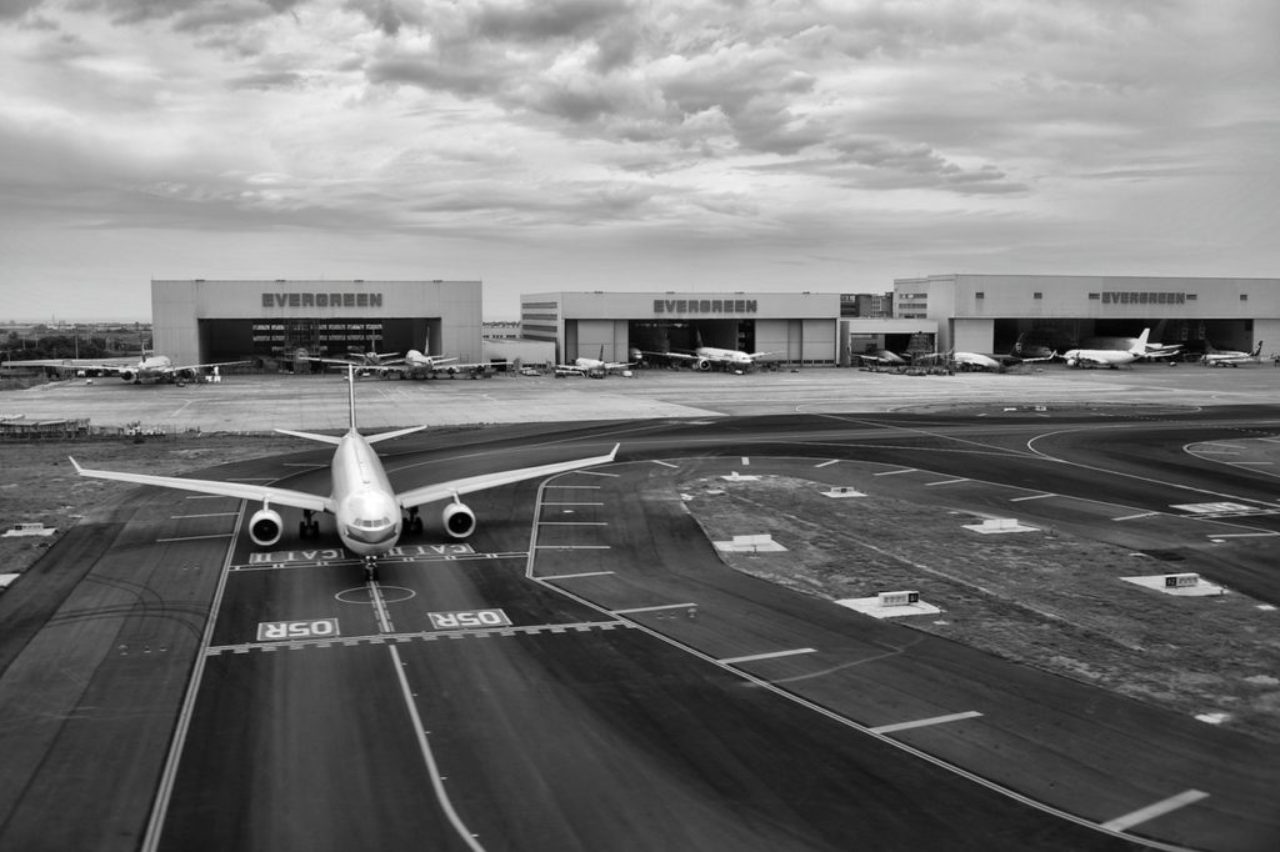 gray-scale-of-air-plane-on-runway-under-cloudy-day