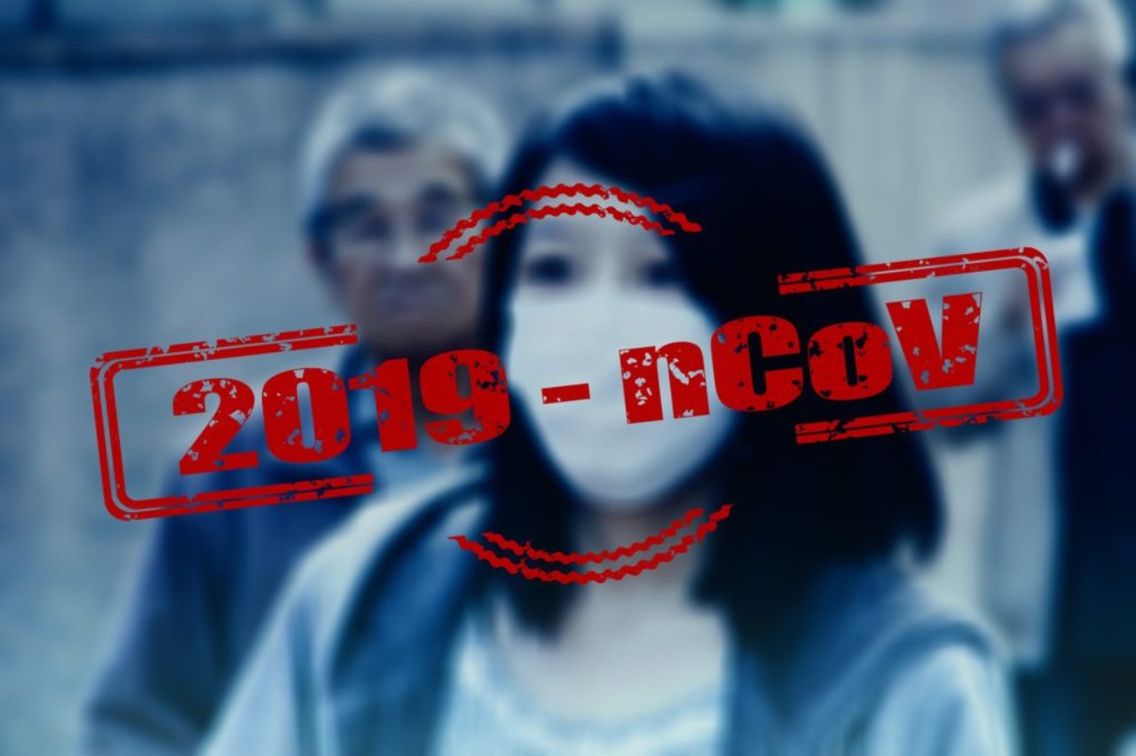 blurred-image-of-female-wearing-face-mask-with-2019-ncov-bold-type