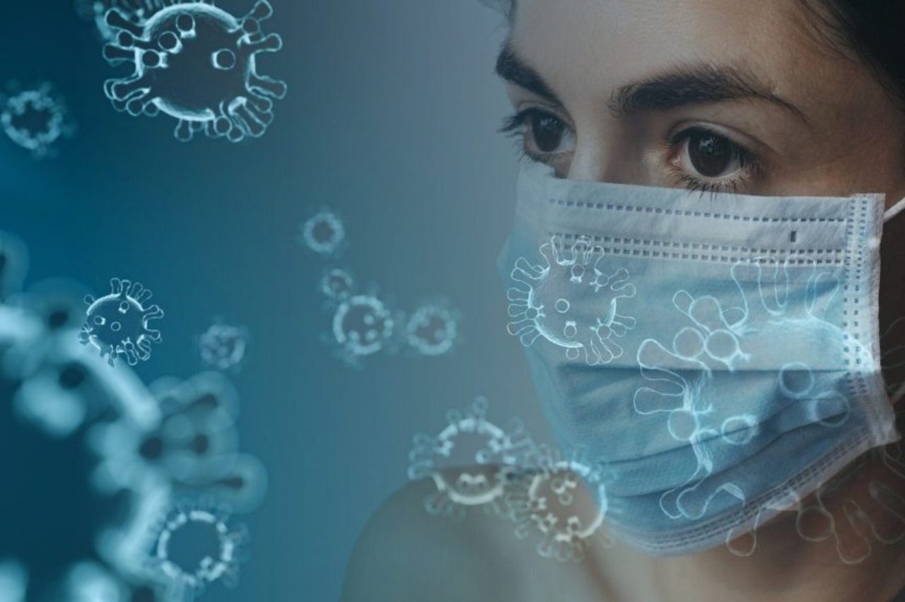 female-wearing-surgical-mask-surriunded-by-graphic-coronavirus-4914026