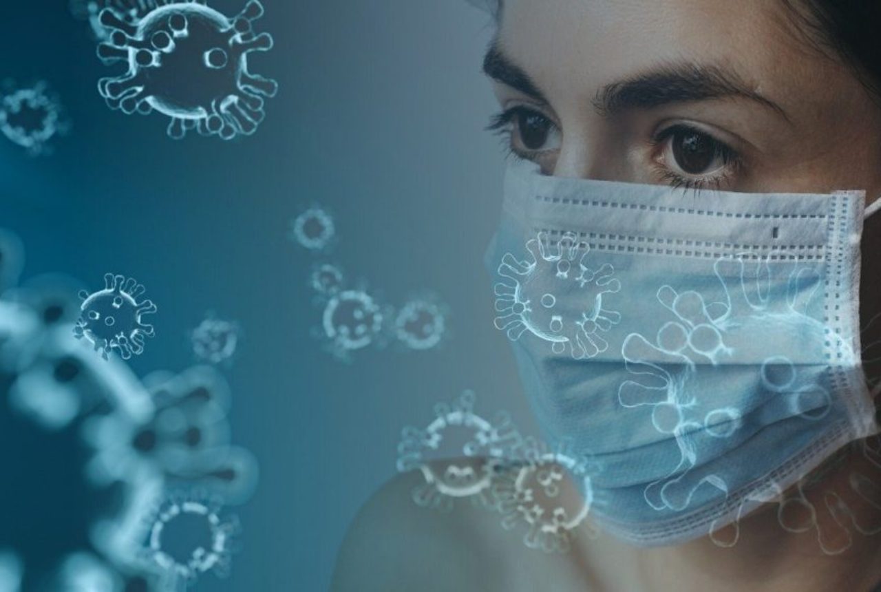 female-wearing-surgical-mask-surriunded-by-graphic-coronavirus-4914026