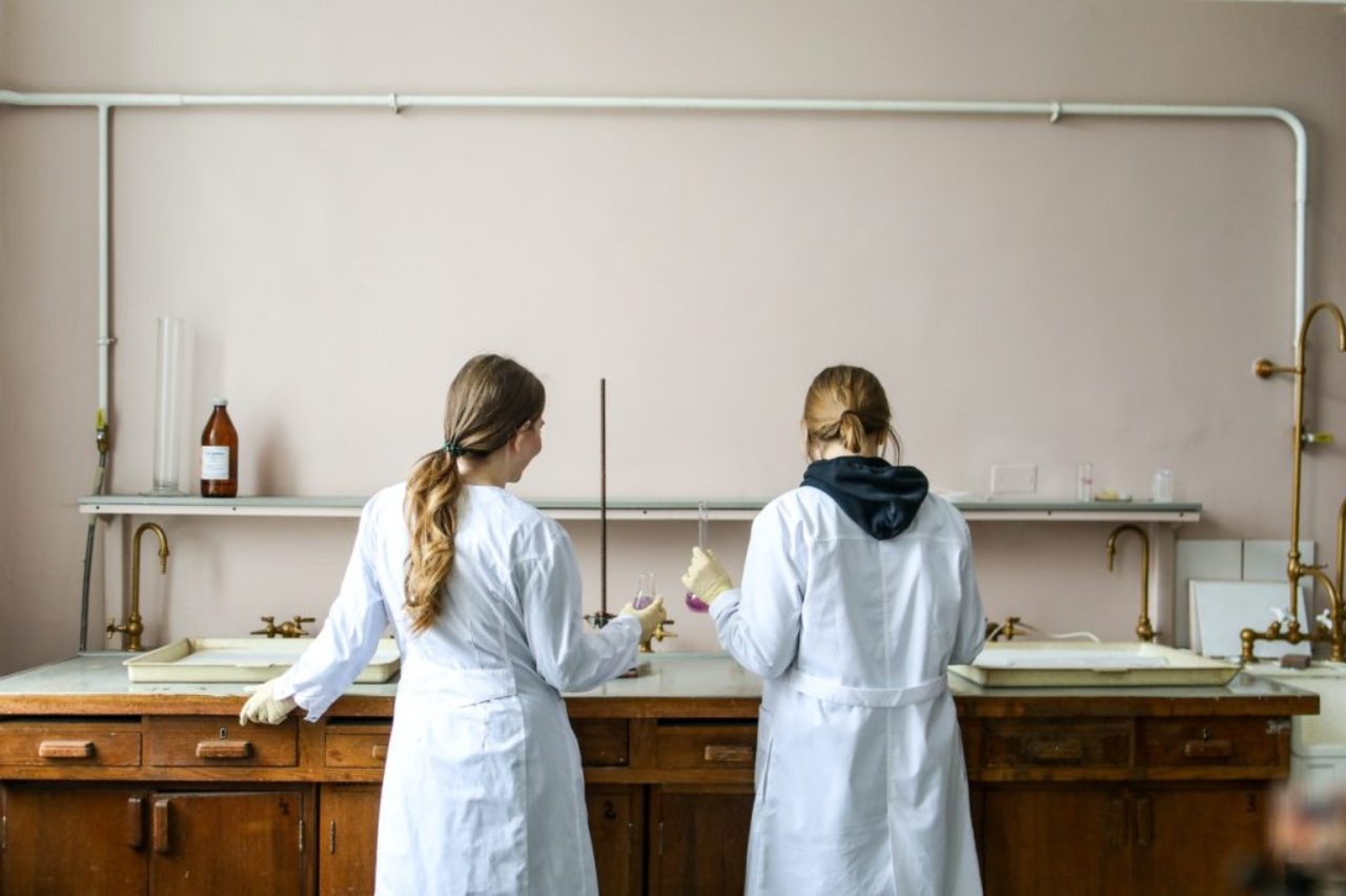 two-females-in-labcoats-at-a-workstation