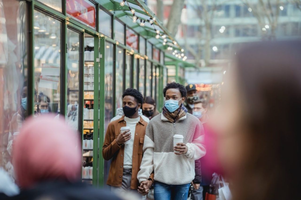 black-homosexual-couple-in-medical-mask-walking-on-crowded-street-6314946/