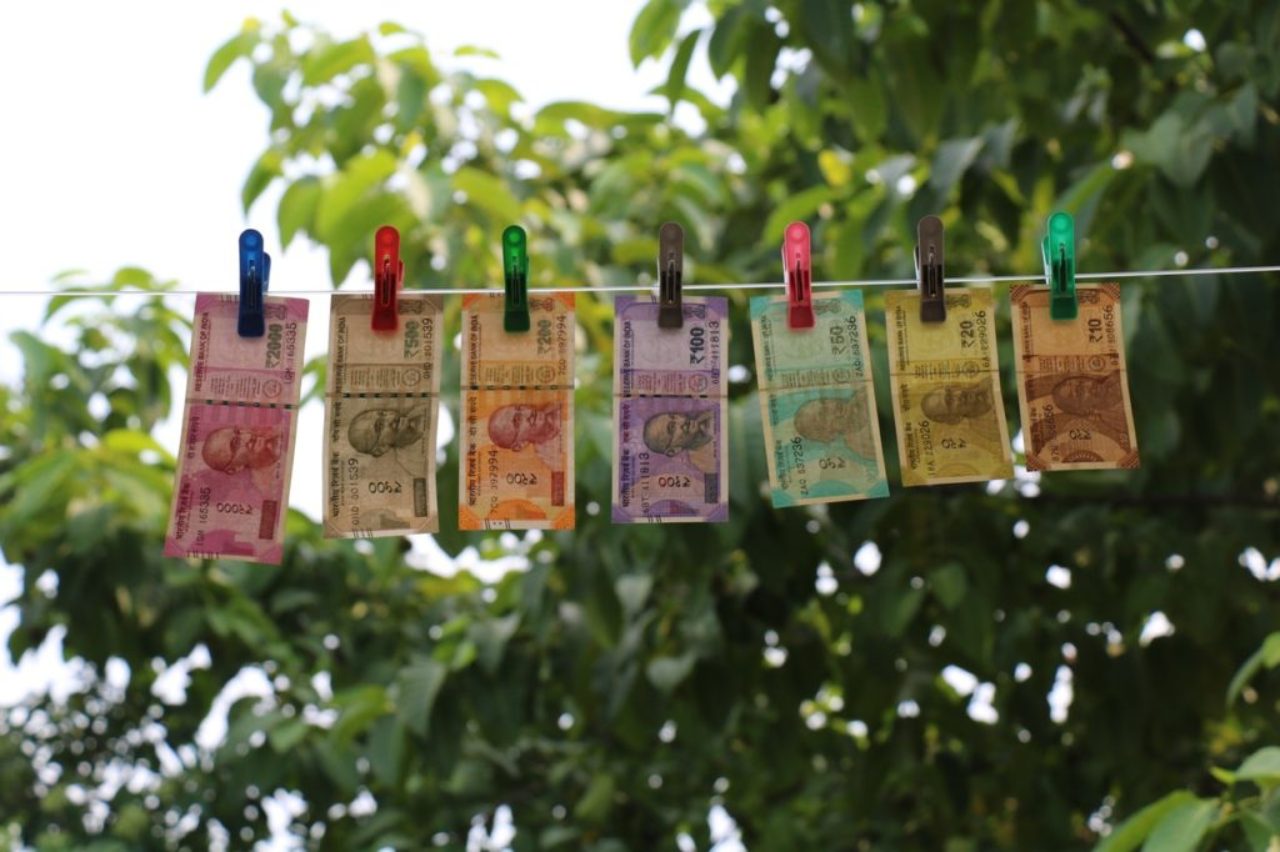 seven-indian-rupee-banknotes-hanging-from-clothesline-on-clothes-pegs